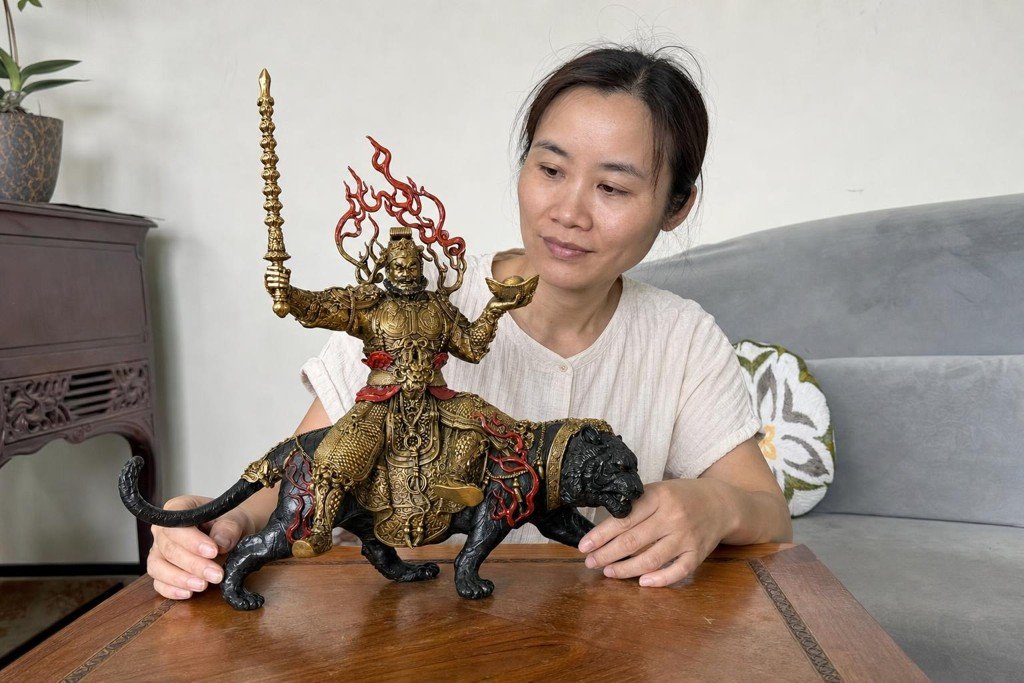 Zhao Gongming Wealth God statue on a black tiger with a Malaysian Chinese woman in a home setting